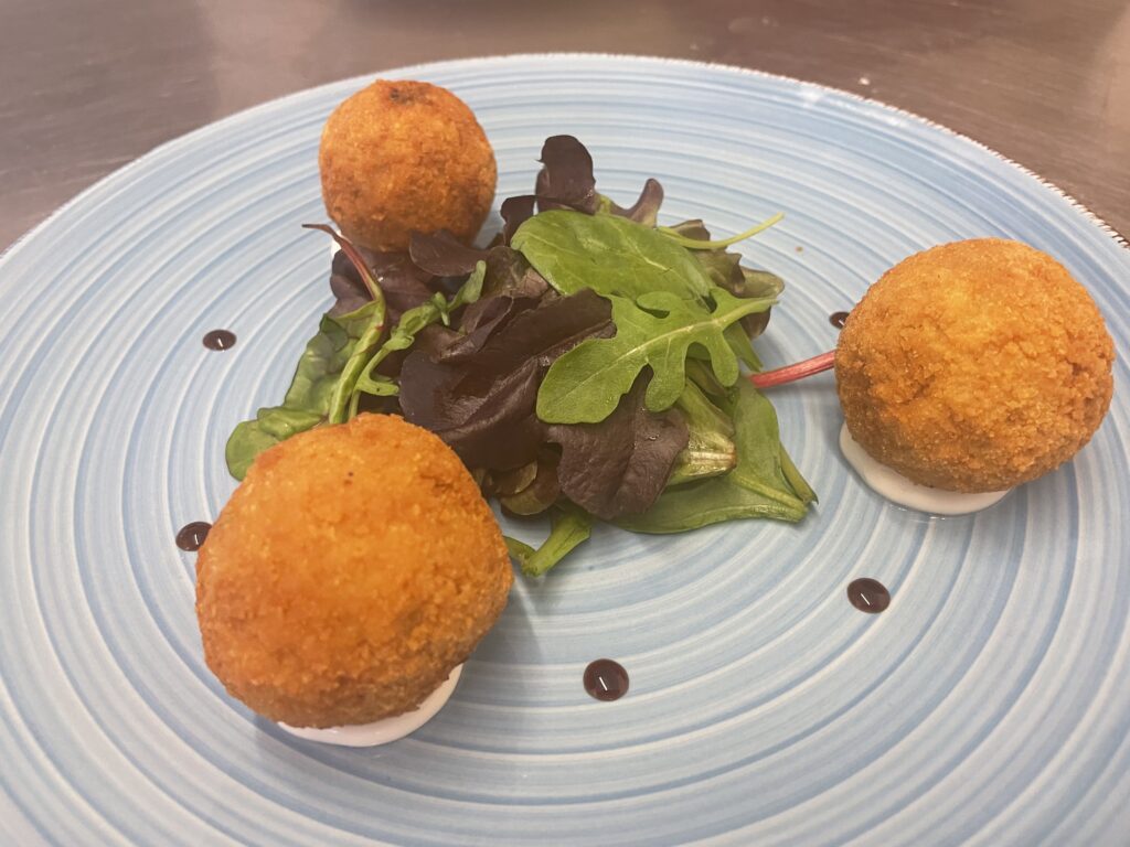 Golden arancini served with salad